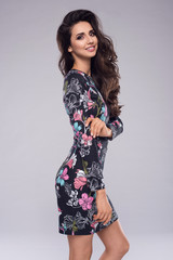 Fashion photo of a beautiful elegant young woman in a pretty dress with flowers holding handbag posing. Fashion spring summer photo