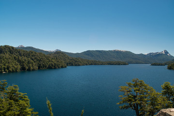 Landscape of a lake with island, with snowy mountain and blue sky