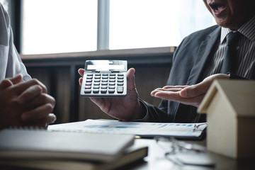 Real estate broker agent being analysis and making the decision a home estate loan to customer, Agent man is using calculator to presentation detail and waiting for his reply to finish