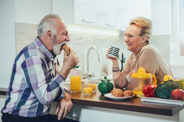 Elderly couple in the kitchen preparing breakfast