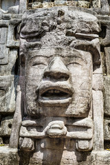 Fototapeta na wymiar Old ancient stone Mayan pre-columbian civilization carved face and ornament, Lamanai archeological site, Orange Walk District, Belize