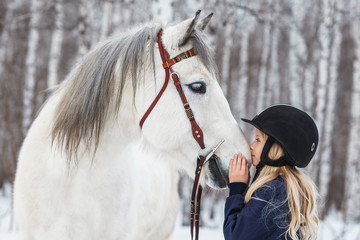 Little girl with a friesian horse, outdoor