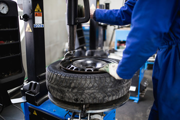 Mechanic repairing tire. Worker vulcanize used tire.