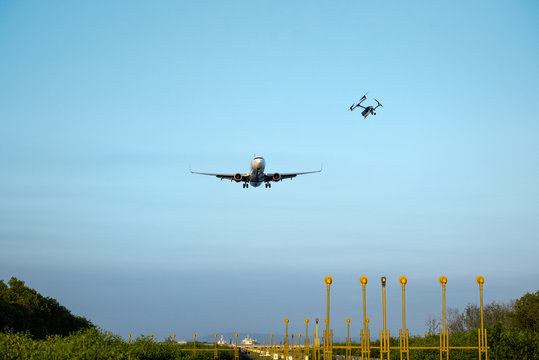 A drone flying dangerously close to a landing airplane. Airport no fly zone. Danger of disaster, collision or crash.