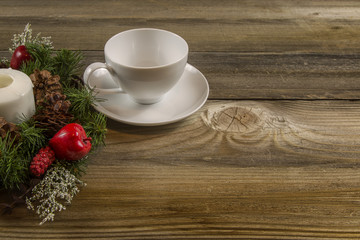 Coffee Cup on wooden table with a wreath oriented to the left