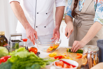 Obraz na płótnie Canvas professional cook teaches to cook woman vegetarian meal.