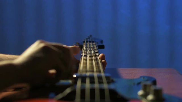Guitarist in studio trying to play on refurbished bass guitar