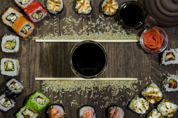 Sushi background of backdrop. Chopsticks lie in parallel. A bowl with sauce is located in the center.