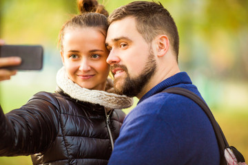 Fototapeta premium couple in love in autumn makes selfie