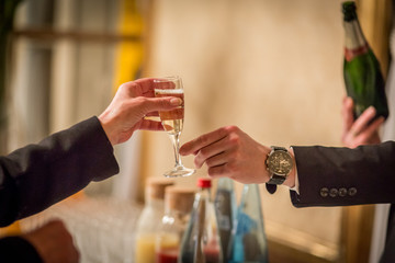 waiter in black suit serving champagne