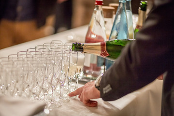 waiter in black suit serving champagne