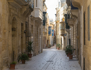 Obraz premium Pusta ulica między tradycyjnymi domami w mieście Vittoriosa, Three Cities, Malta