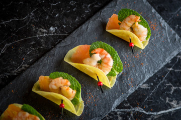 shrimp appetizers on black plate 