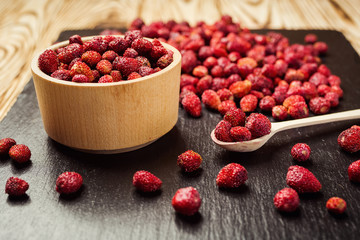 red strawberries in bowl on a wooden background