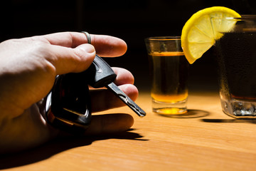 A man's hand holding car keys at a bar
