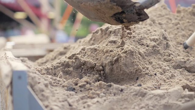 Shovel digging sand from large pile close up