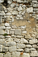 Full frame texture background of an old badly repaired rubble stone wall construction