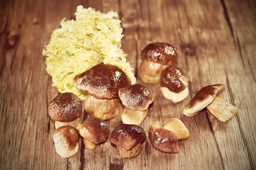 Frozen boletus mushrooms on wooden background. White mushrooms.