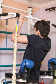 A Teenage Sportsman Is Pushed Up At Home On A Swedish Wall