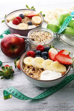 muesli with dairy and fruit, healthy lifestyle. bowl of cereal, fruit and dumbbell