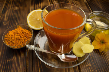 Tea with turmeric on the   brown wooden background