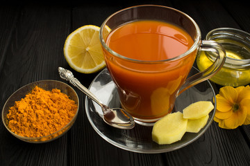 Tea with turmeric on the black  wooden background