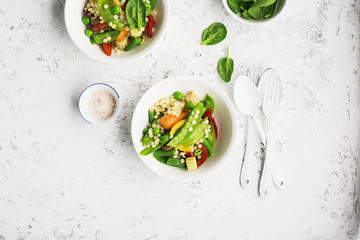 Pearl couscous with fresh vegetables bowl. Young green peas pod, corn, baby carrots, spinach, beans. On a light background. Food concept.