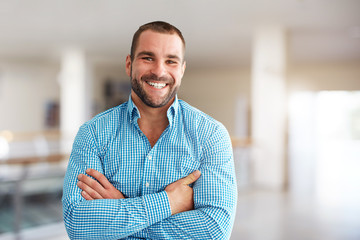 Smiling man standing in business center - Powered by Adobe