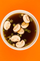 Bowl Of Japanese Style Clear Onion Soup With Mushrooms and Spring Onions