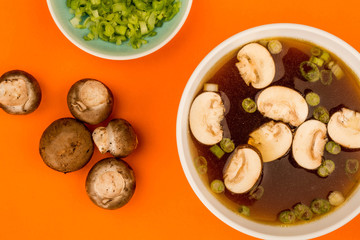 Bowl Of Japanese Style Clear Onion Soup With Mushrooms and Spring Onions