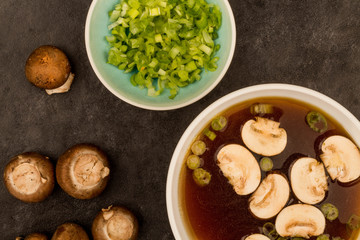 Bowl Of Japanese Style Clear Onion Soup With Mushrooms and Spring Onions