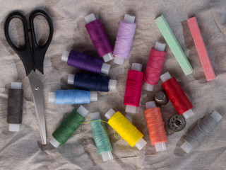 Colored threads, scissors, needles and bobbins