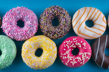 A background of colorful tasty donuts. Close up.