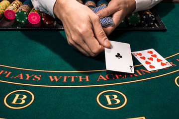 Close up of holdem dealer with playing cards and chips on green table - obrazy, fototapety, plakaty
