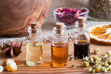 Bottles of essential oil with star anise, chamomile and frankincense