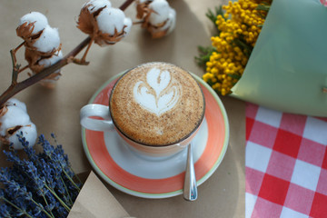 Cappuccino and dried flowers on a table