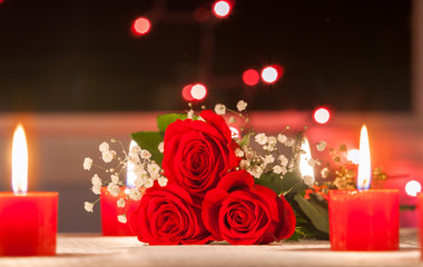 Beautiful red roses net to candle lights. 