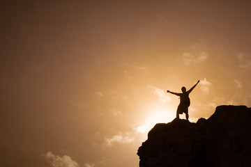 Obraz na płótnie Canvas Man standing on top a mountain feeling free.