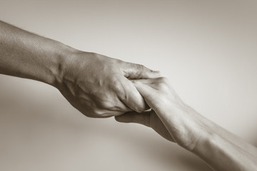 Hand holding up hand. Giving blessing and help. 