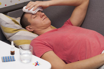man with headache lying on the sofa
