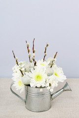 Floral arrangement  inside silver watering can.