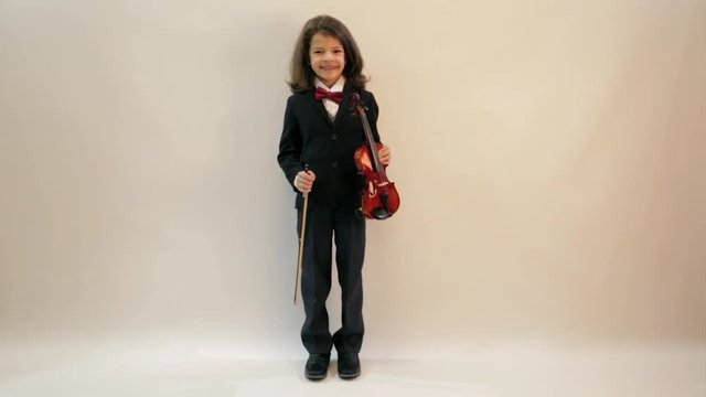 A young handsome musician plays the violin. Gray background. In full growth.