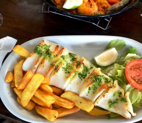 Grilled calamari, vegetables and french fries. Close up.