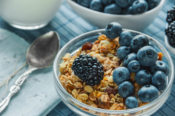 Healthy Breakfast cereals: muesli with fruits and berries blueberries, blackberries and dairy products. Selective focus. Close up.