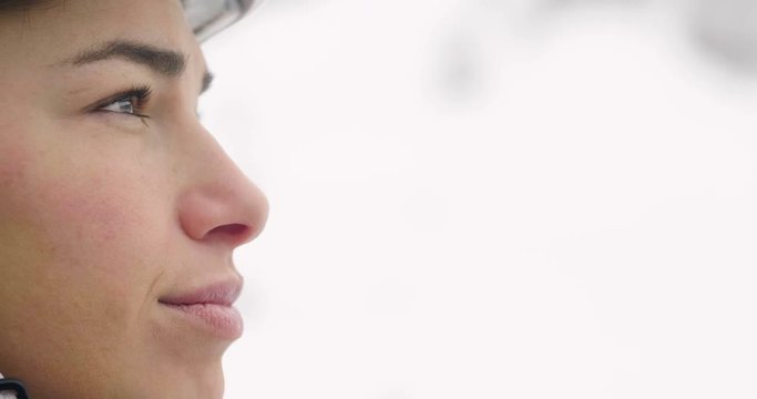Close-up of a smiling skier's face on a vacation in the mountains, peering over the ski slopes. Concept of: holidays, sport, passion, skiing.