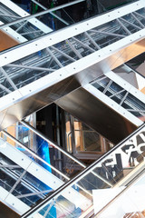 Fototapeta premium Several escalators with transparent side panels intersect in a beautiful geometric form.