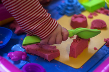 Pink kinetic sand, educational game for children. The development of motor skills in boys and girls
