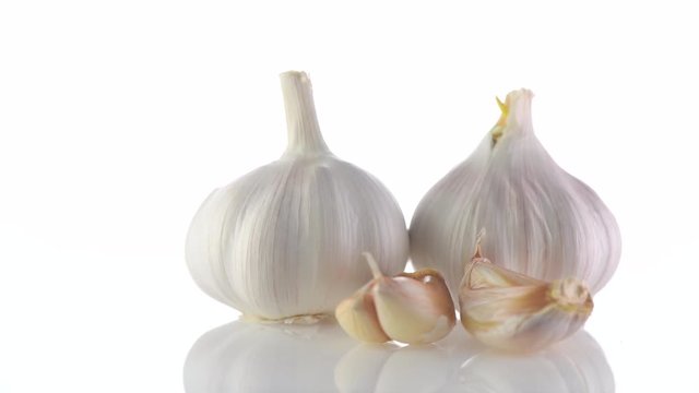 Garlic. Organic raw garlic bulb rotated on white background. 4K UHD video footage. 3840X2160