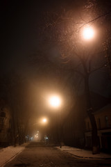 Picture of gloomy night with street lights and fog. Low light image.