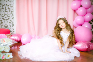 Girl with blond long hair in light-pink dress of a princess and tiara with balloons around © capable97